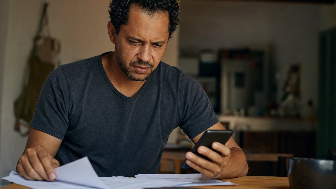Calculadora, FGTS e termo de rescisão representando o Crédito do Trabalhador e a multa rescisória