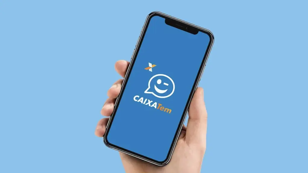 Mão segurando um celular com o app Caixa Tem aberto.
