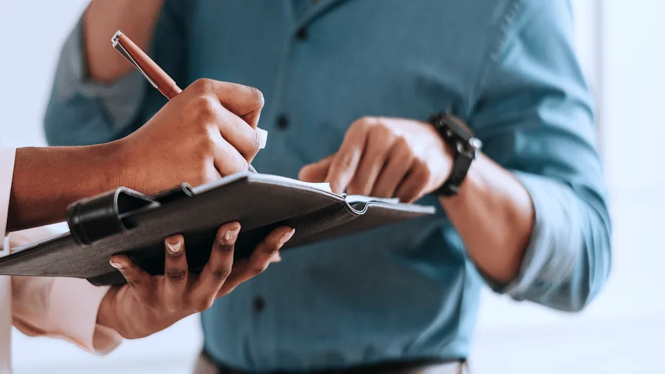 Profissional de RH conferindo um checklist em prancheta