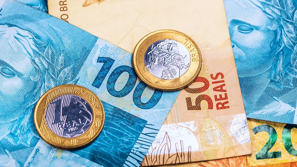 Cédulas e moedas de real representando o desconto do Crédito do Trabalhador