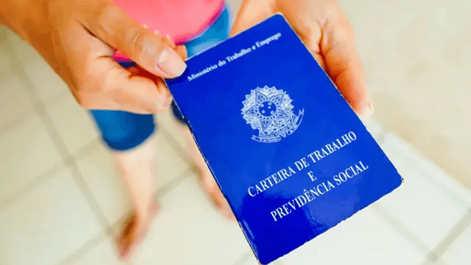 A empresa pode negar o consignado CLT? O que diz a regra em 2026 1 Mão segurando a carteira de trabalho, símbolo do vínculo CLT