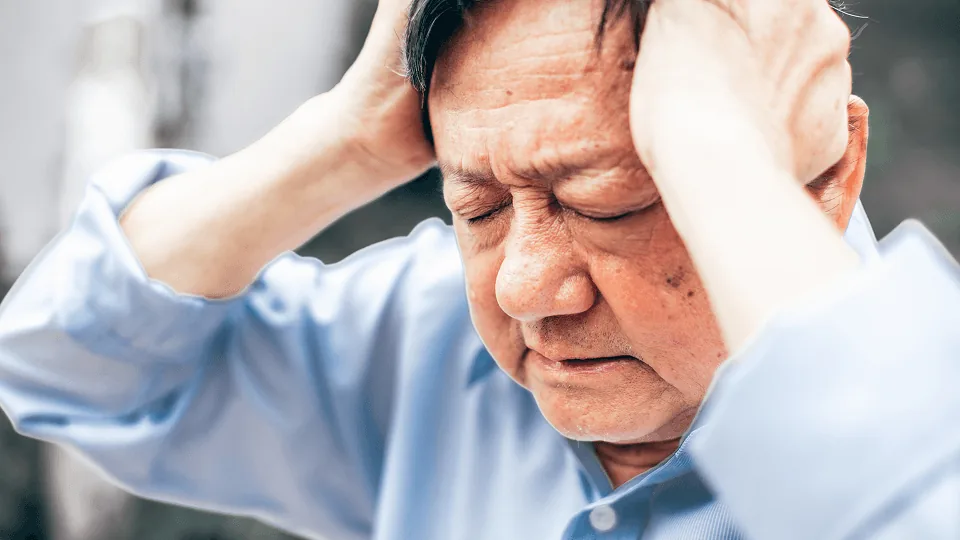Trabalhador preocupado com as mãos na cabeça diante de um estorno no holerite