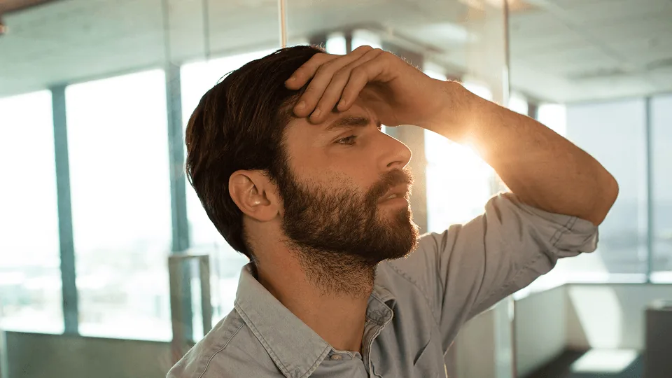 Trabalhador com a mão na testa ao ver estorno de provisão no holerite