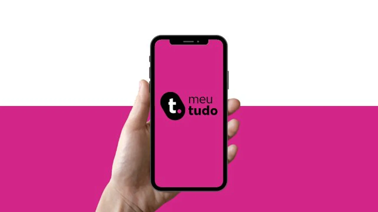 Mão segurando um celular com o logo da meutudo sobre fundo rosa.