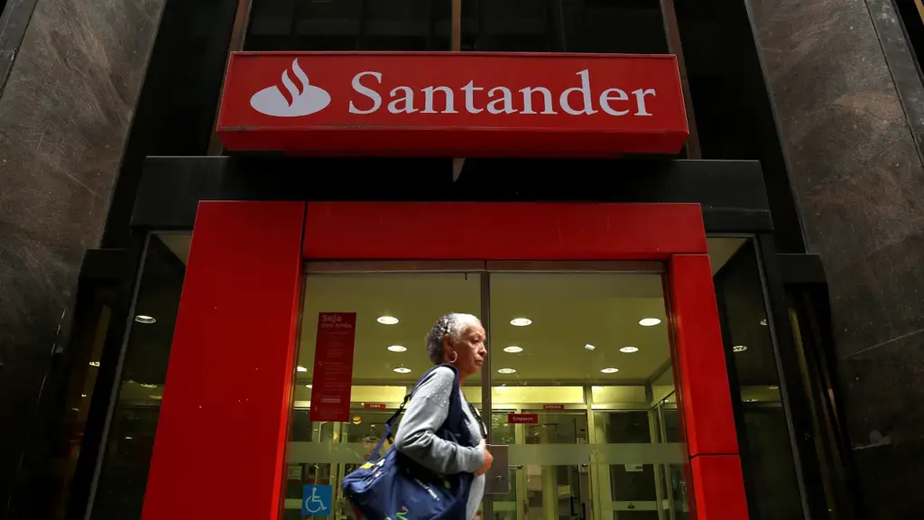 Fachada de uma agência do Santander com pessoa entrando.