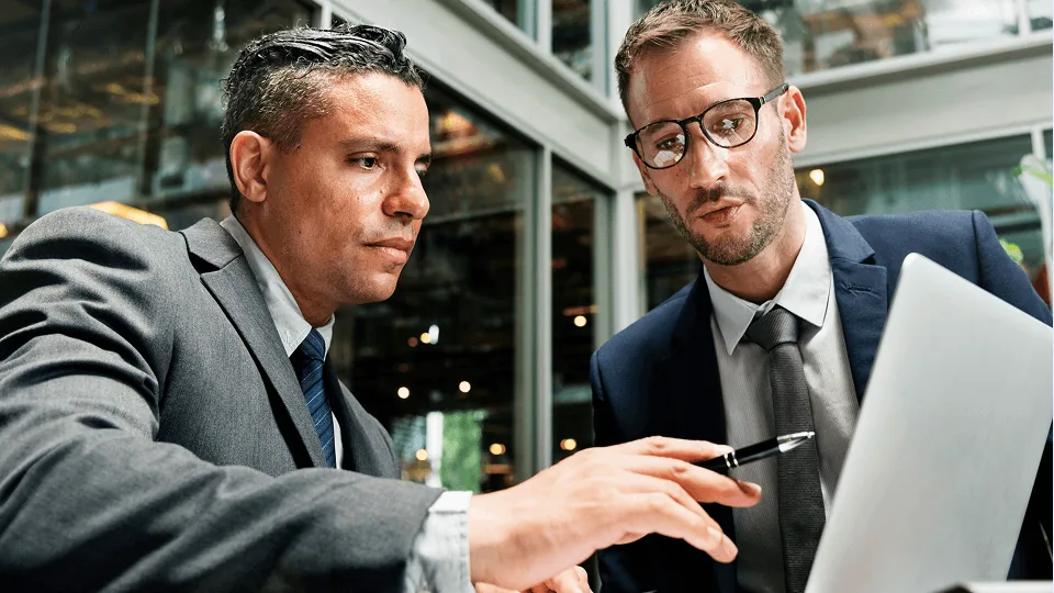 Dois profissionais analisando no notebook a virada de competência do Crédito do Trabalhador